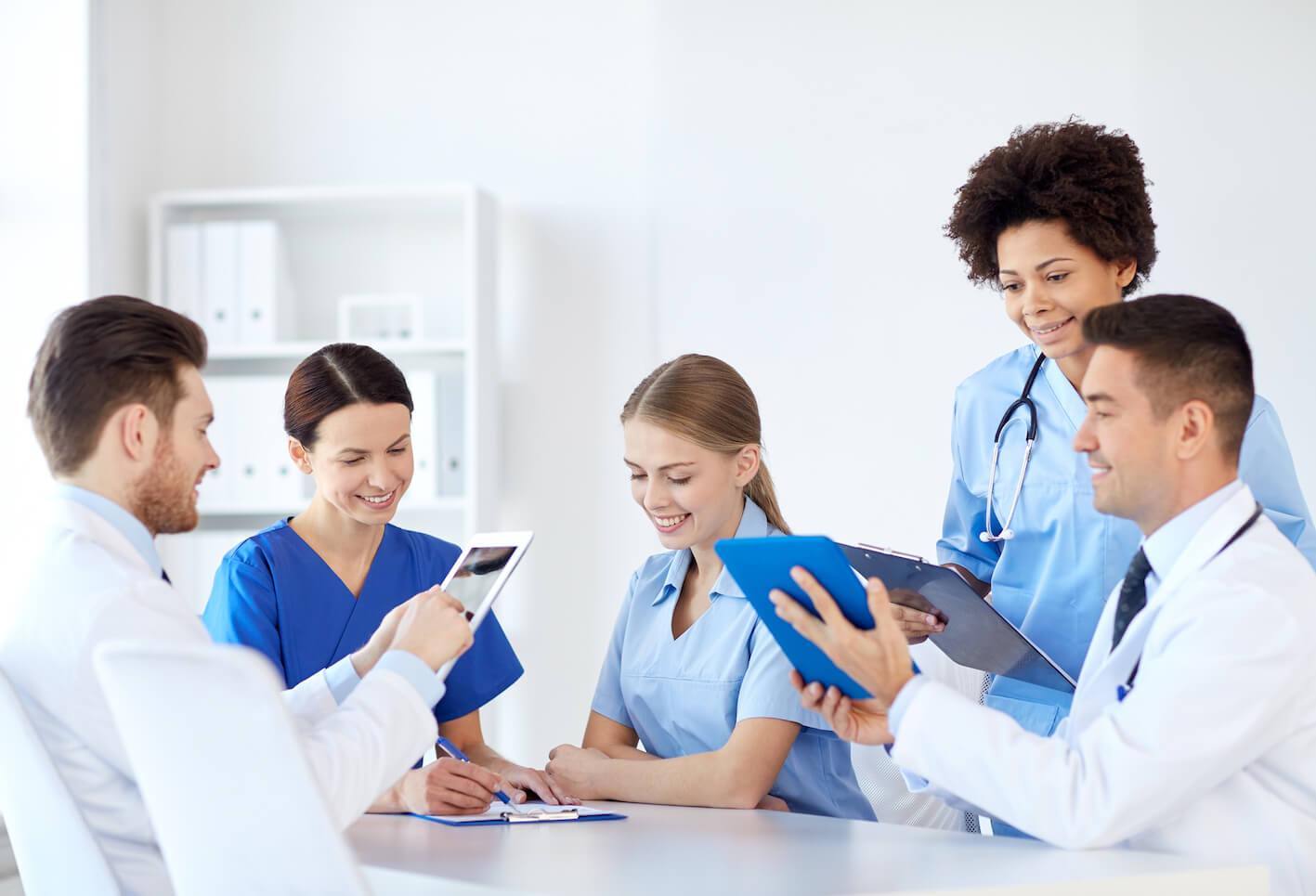 hospital-profession-people-and-medicine-concept-group-of-happy-doctors-with-tablet-pc-computers-meeting-at-medical-office1